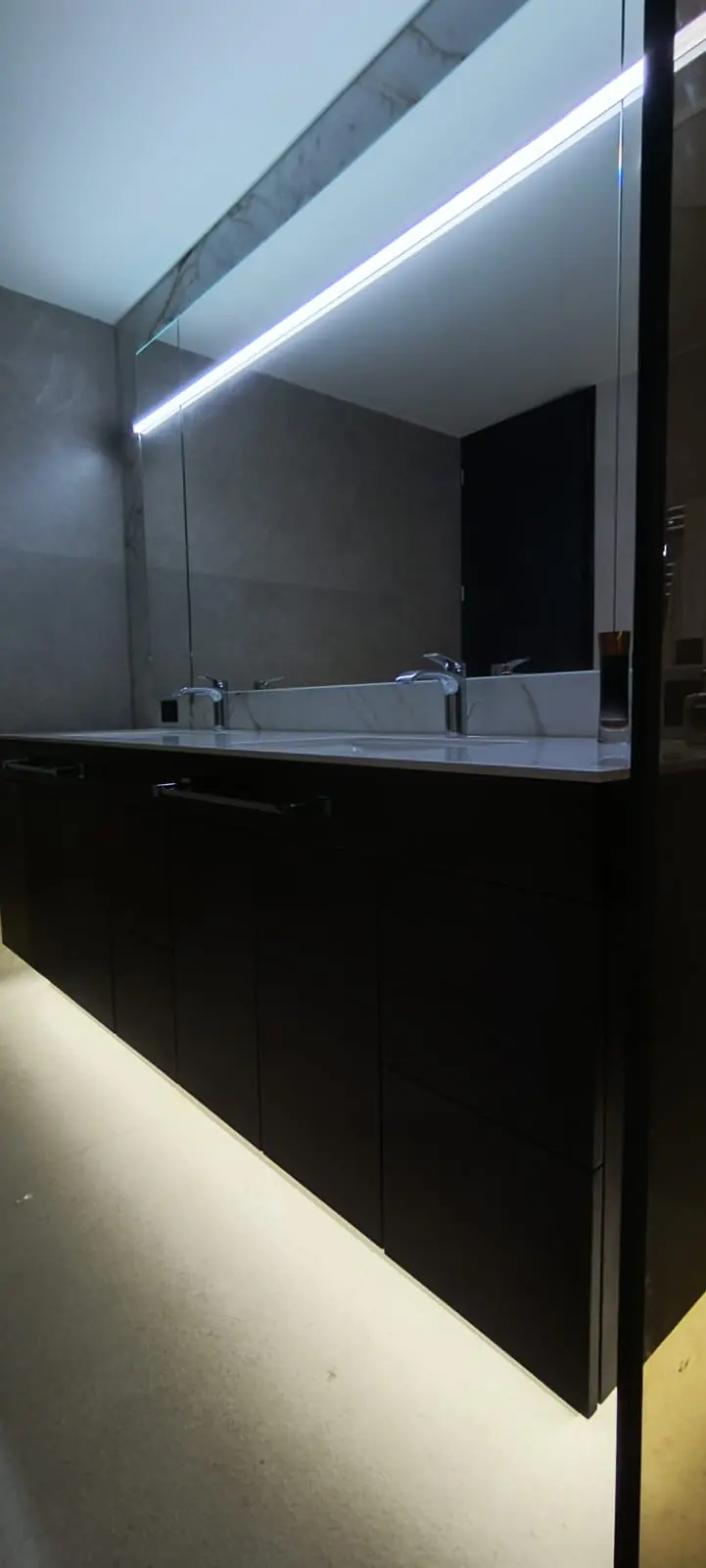Espejo a medida con iluminación LED integrada sobre mueble de baño